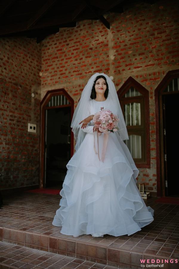 Bride in beautiful wedding dress with off the shoulder poses against the  concrete walls, runs his hands along the wall Stock Photo | Adobe Stock