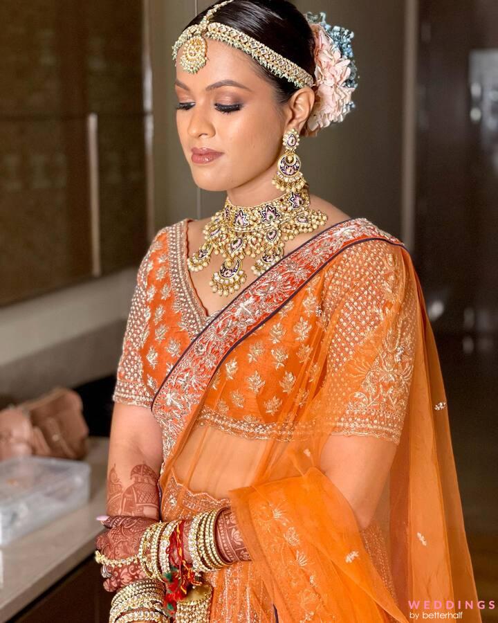 Premium Photo | Gujarati bride in royal orange and gold lehenga displays  tradition through her jewelry and gracious