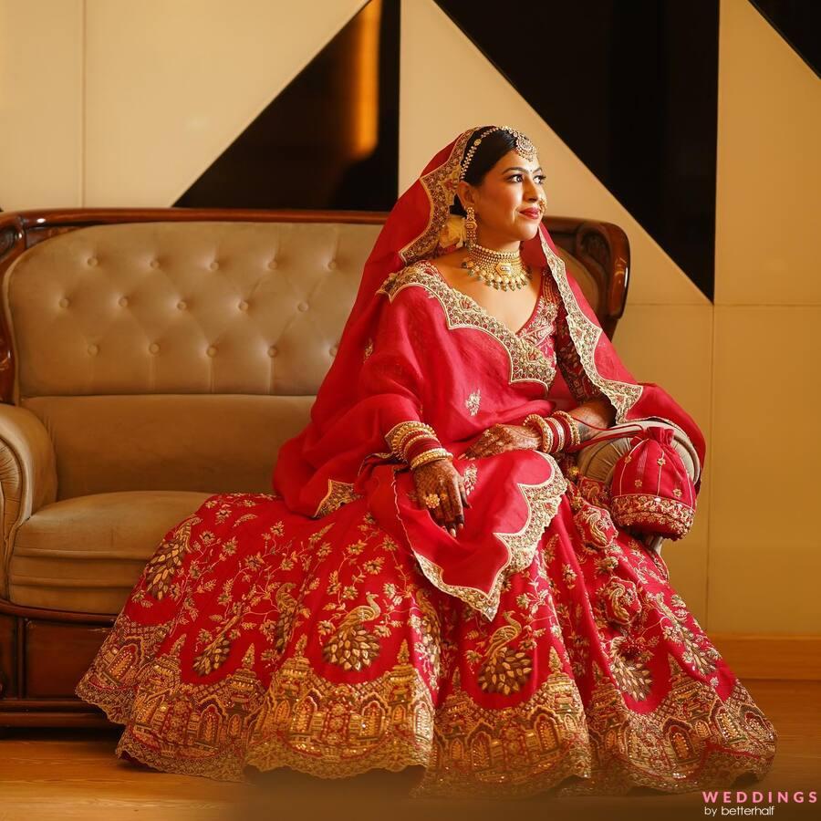 Photo of A bride wearing a traditional red lehenga