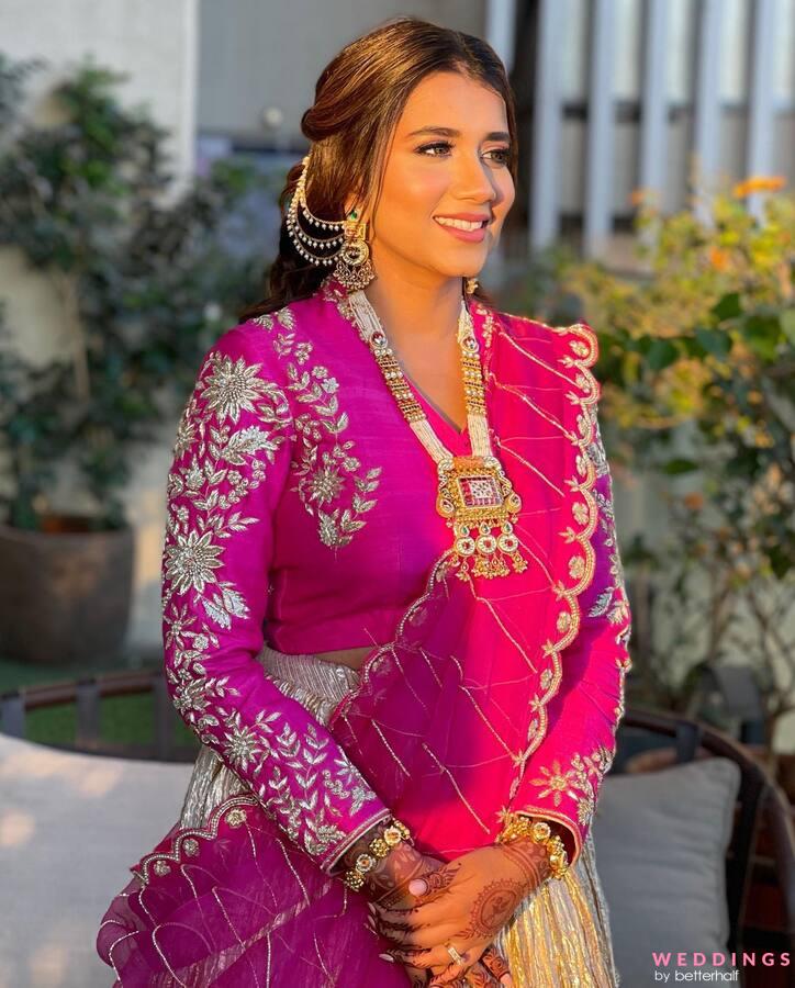 Photo of Pretty bride in pastel pink lehenga with gold jewellery