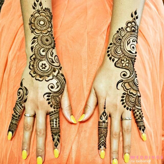 Elegant backhands henna designs on hands paired with vibrant yellow nail polish