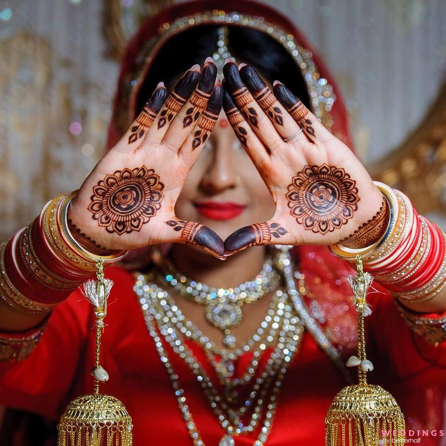 Photo of Bride posing with her mother and sister on her Mehndi ceremony.